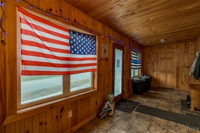 doorway featuring wooden walls and wood ceiling