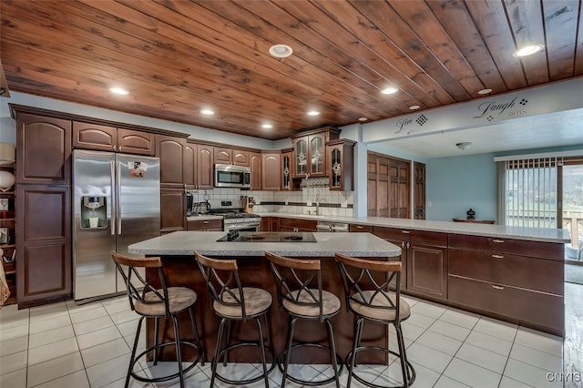 kitchen featuring a large island, kitchen peninsula, stainless steel appliances, and wooden ceiling