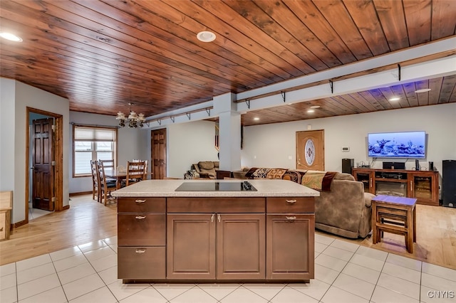 kitchen with wooden ceiling, a center island with sink, light hardwood / wood-style flooring, and a notable chandelier