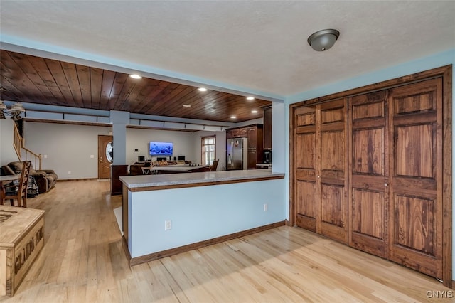 kitchen featuring light wood-type flooring, kitchen peninsula, wood ceiling, and stainless steel fridge