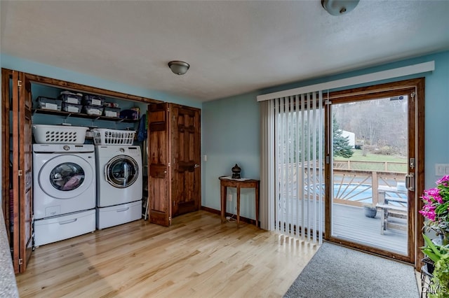 laundry room featuring washer and clothes dryer and light hardwood / wood-style flooring