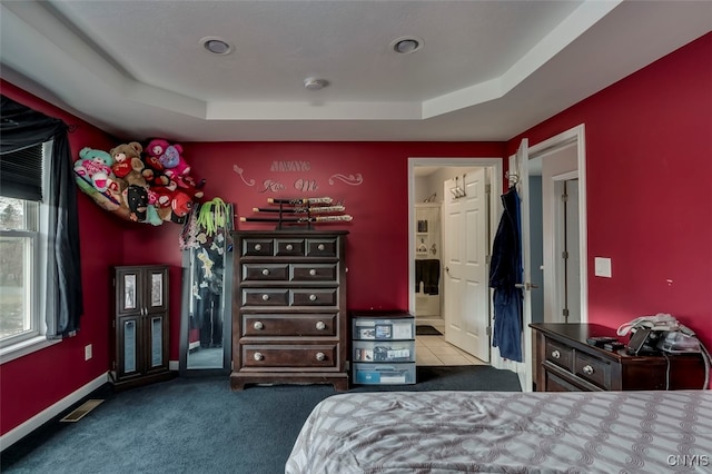 bedroom with a tray ceiling and carpet