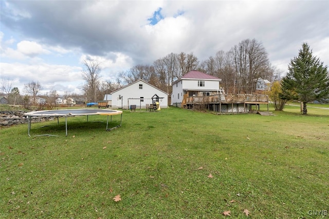 view of yard featuring a wooden deck and a trampoline