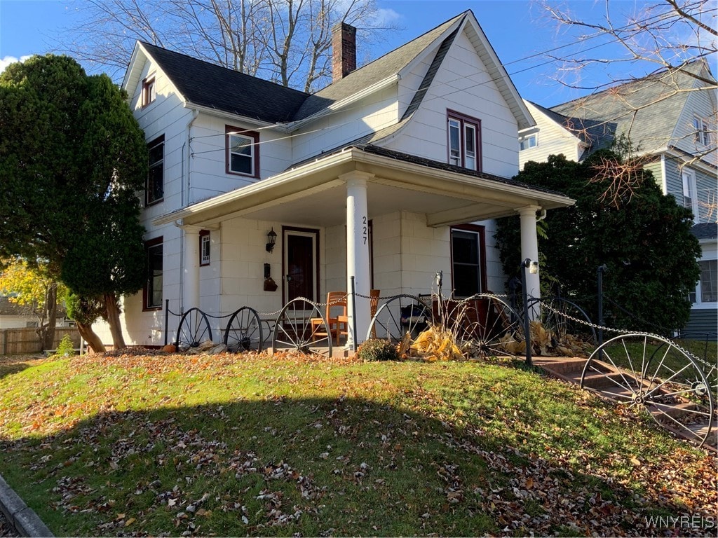 view of front of house featuring covered porch and a front lawn