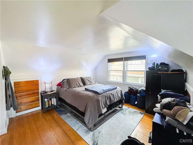 bedroom with vaulted ceiling and wood-type flooring