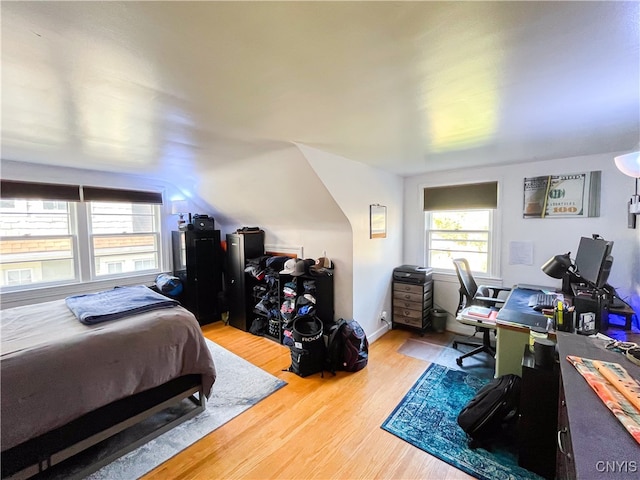 bedroom with lofted ceiling and hardwood / wood-style flooring