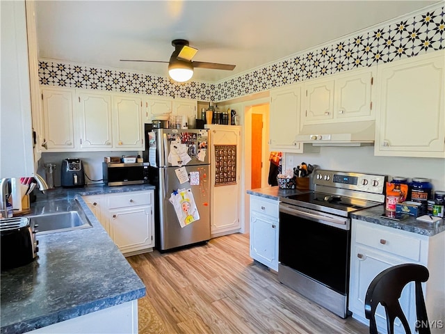 kitchen featuring stainless steel appliances, white cabinetry, sink, light hardwood / wood-style floors, and ceiling fan