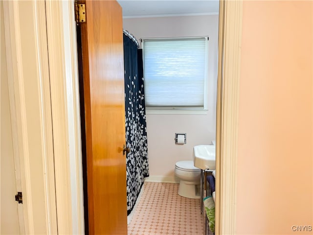 bathroom with ornamental molding and toilet