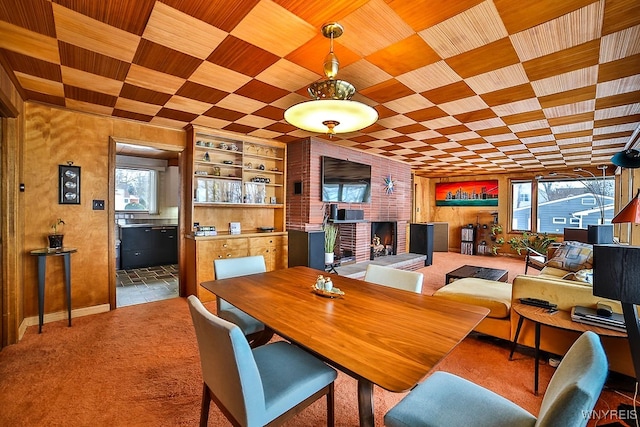 dining area with carpet flooring, a fireplace, and built in shelves