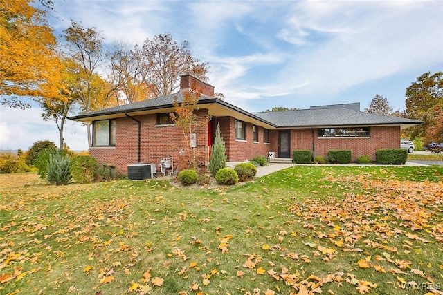 view of front of home featuring central AC unit and a front yard