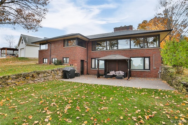 rear view of house with a lawn and a patio