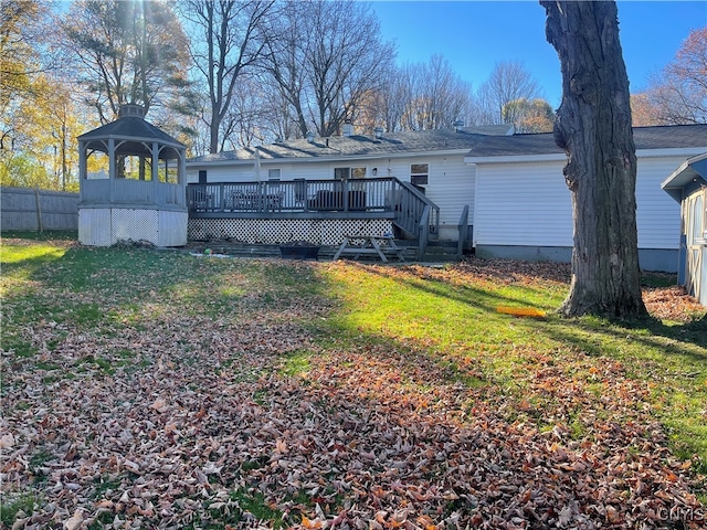 rear view of property featuring a yard and a deck