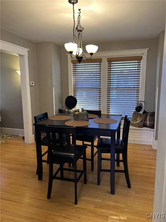 dining space featuring light hardwood / wood-style floors and a chandelier