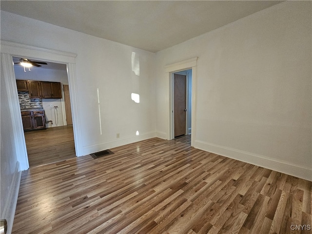 unfurnished room featuring dark hardwood / wood-style floors and ceiling fan