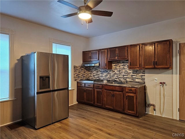 kitchen with light hardwood / wood-style floors, light stone counters, tasteful backsplash, stainless steel fridge with ice dispenser, and ceiling fan