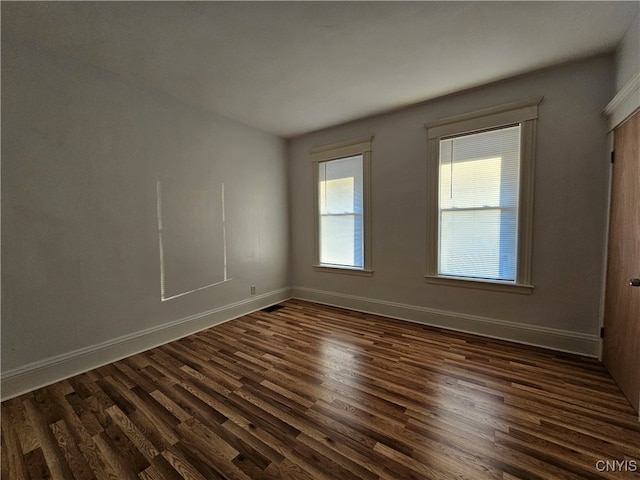 unfurnished room with dark hardwood / wood-style flooring