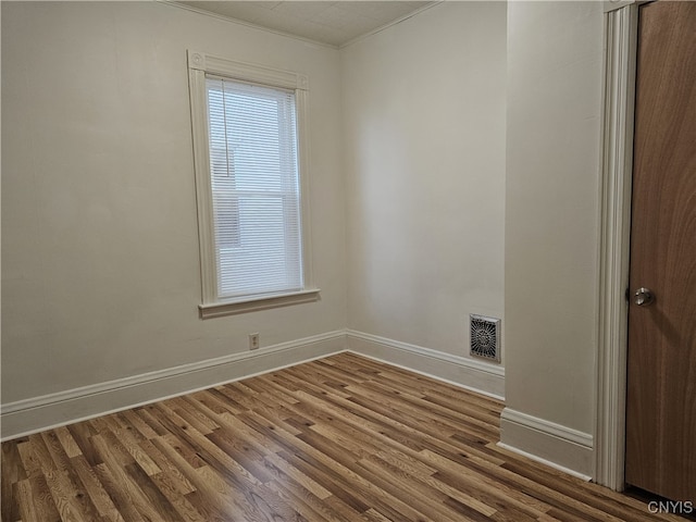 unfurnished room featuring hardwood / wood-style floors and ornamental molding