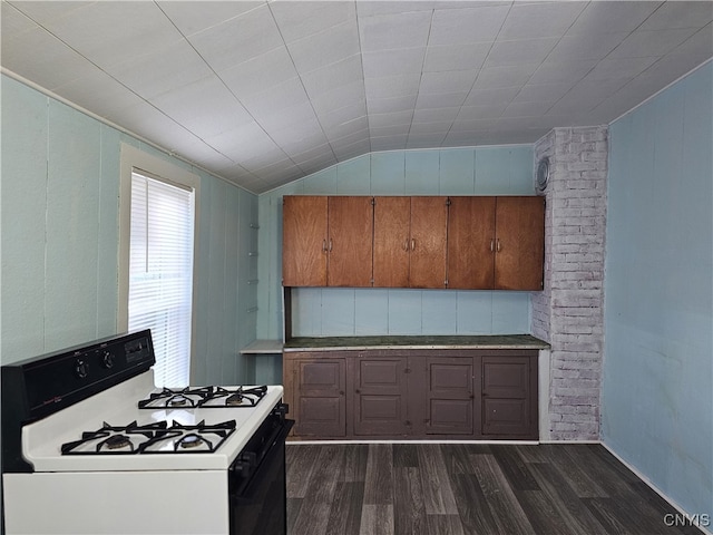 kitchen with gas range gas stove, dark hardwood / wood-style flooring, and vaulted ceiling