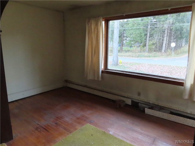 spare room with hardwood / wood-style flooring, plenty of natural light, and a baseboard radiator