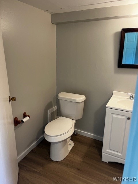 bathroom featuring wood-type flooring, vanity, and toilet