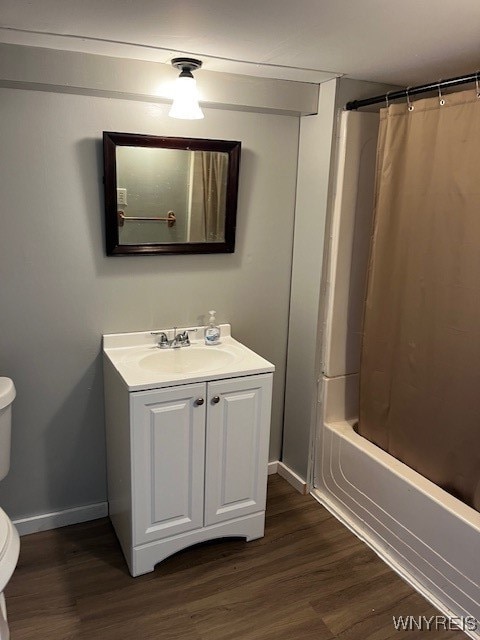 full bathroom featuring shower / bath combo, vanity, hardwood / wood-style flooring, and toilet