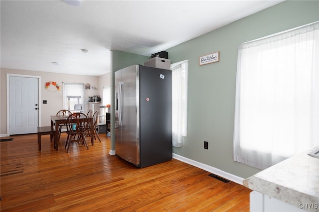 kitchen featuring hardwood / wood-style flooring and stainless steel refrigerator