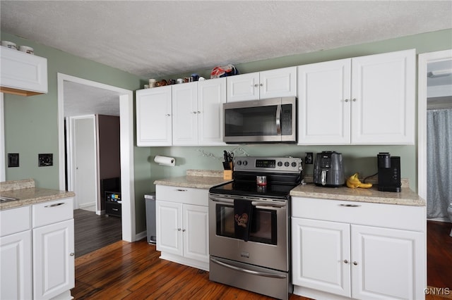 kitchen featuring white cabinets, dark hardwood / wood-style flooring, a textured ceiling, and appliances with stainless steel finishes