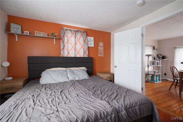 bedroom with lofted ceiling and hardwood / wood-style flooring