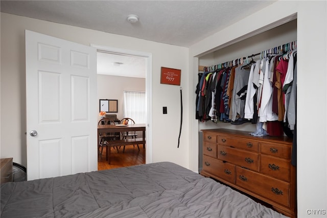 bedroom with a textured ceiling, hardwood / wood-style flooring, and a closet