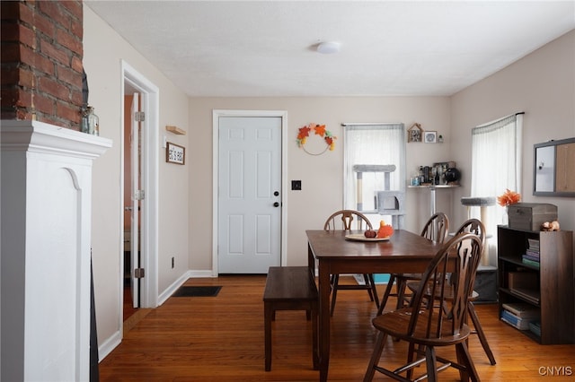 dining space with wood-type flooring