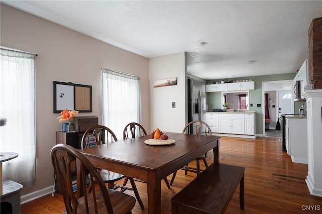 dining area with dark wood-type flooring, a textured ceiling, and sink