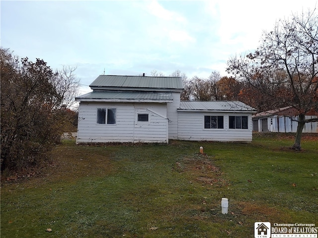 rear view of property featuring a yard