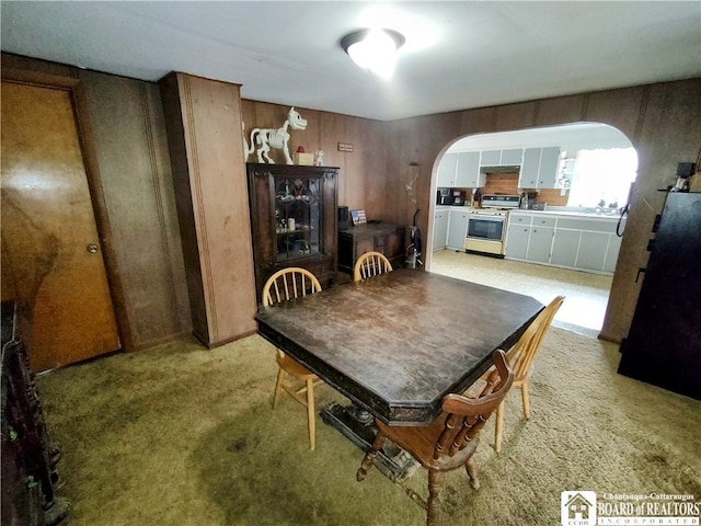 carpeted dining room with wooden walls