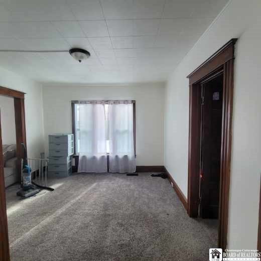 carpeted spare room featuring baseboards