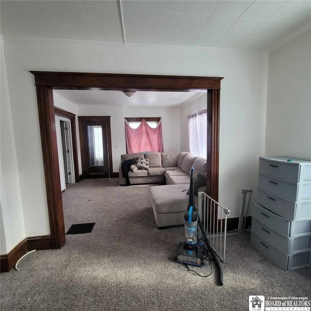 living room featuring visible vents, baseboards, and carpet