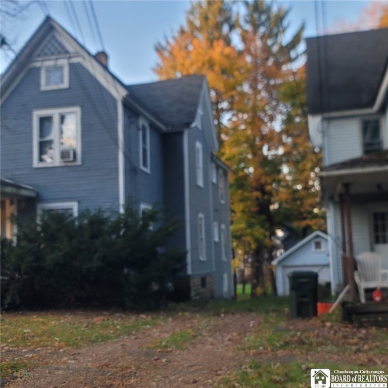 view of side of property with a garage and an outbuilding