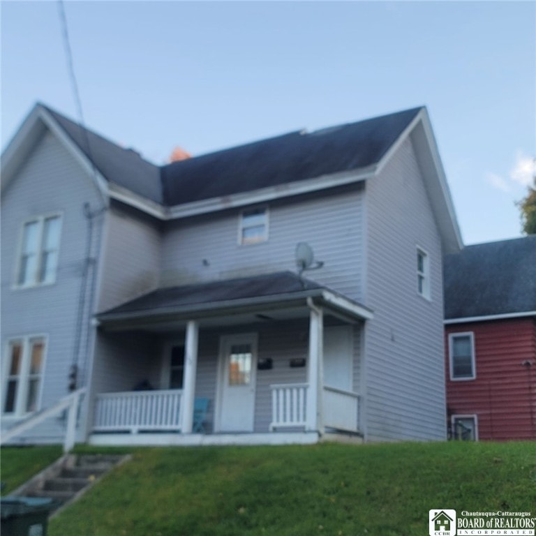 view of front facade featuring covered porch and a front lawn