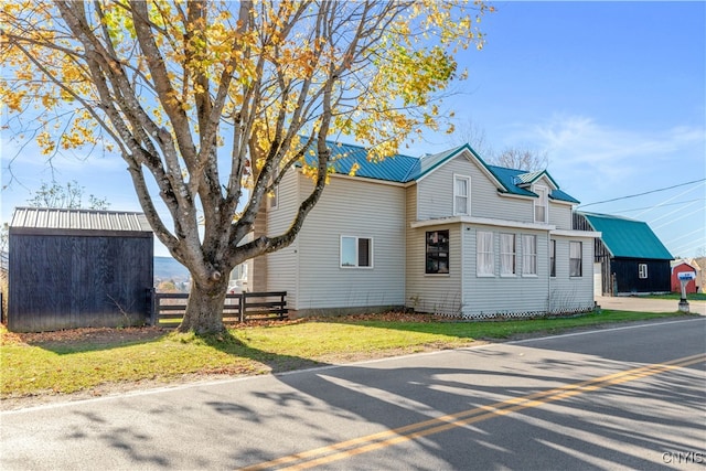 view of front facade featuring a storage unit and a front yard