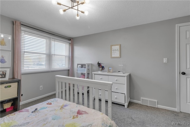 bedroom featuring an inviting chandelier, a textured ceiling, and carpet floors