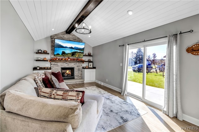 living room featuring light hardwood / wood-style floors, vaulted ceiling with beams, an inviting chandelier, wooden ceiling, and a fireplace