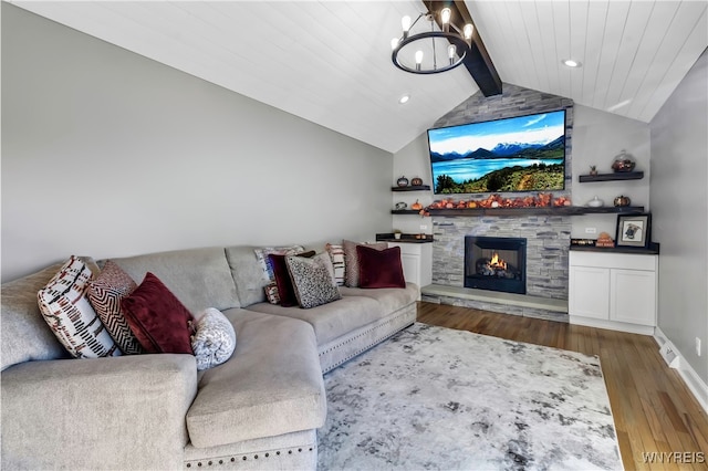 living room featuring lofted ceiling with beams, a stone fireplace, hardwood / wood-style floors, a chandelier, and wooden ceiling