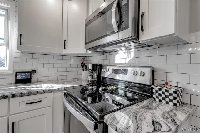 kitchen with white cabinetry, decorative backsplash, and stainless steel appliances