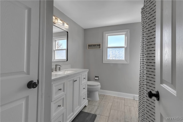 bathroom with toilet, vanity, and tile patterned floors