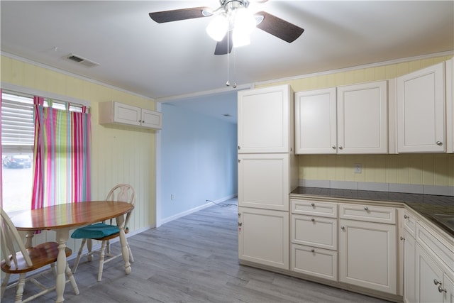 kitchen featuring light hardwood / wood-style flooring, crown molding, ceiling fan, and white cabinets