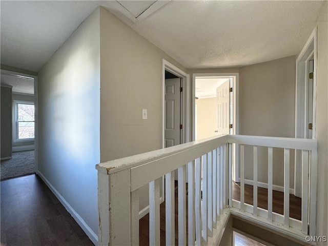 hall with wood-type flooring and a textured ceiling