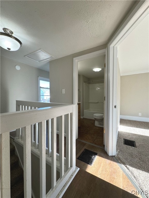 hallway featuring a textured ceiling and dark hardwood / wood-style flooring