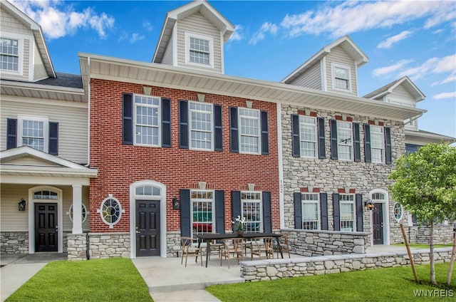 view of front of home with a patio and a front lawn