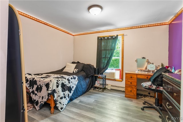 bedroom with cooling unit, hardwood / wood-style flooring, and ornamental molding