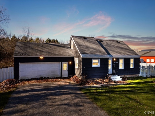 ranch-style home with a garage and a yard