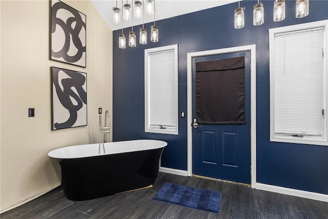 bathroom with a bathtub, lofted ceiling, and hardwood / wood-style floors